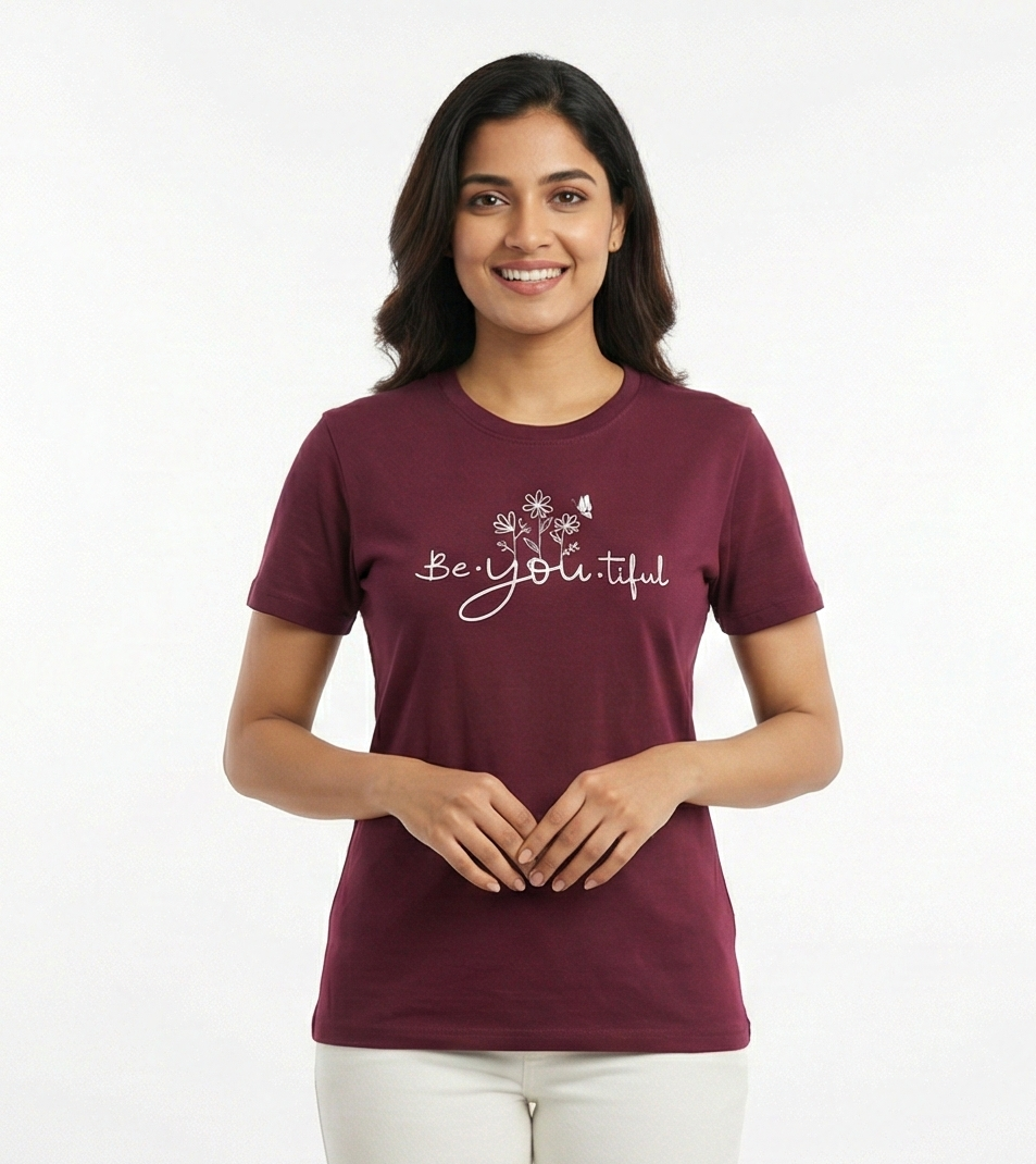 Woman wearing a maroon t-shirt with 'Be Beautiful' text on a white background