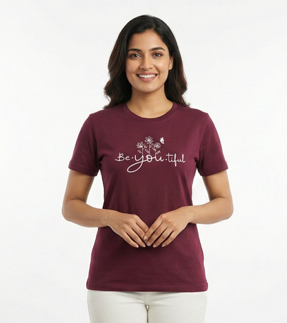 Woman wearing a maroon t-shirt with 'Be Beautiful' text on a white background