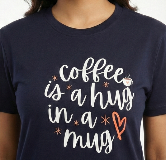 Navy blue t-shirt with 'coffee is a hug in a mug' text design.