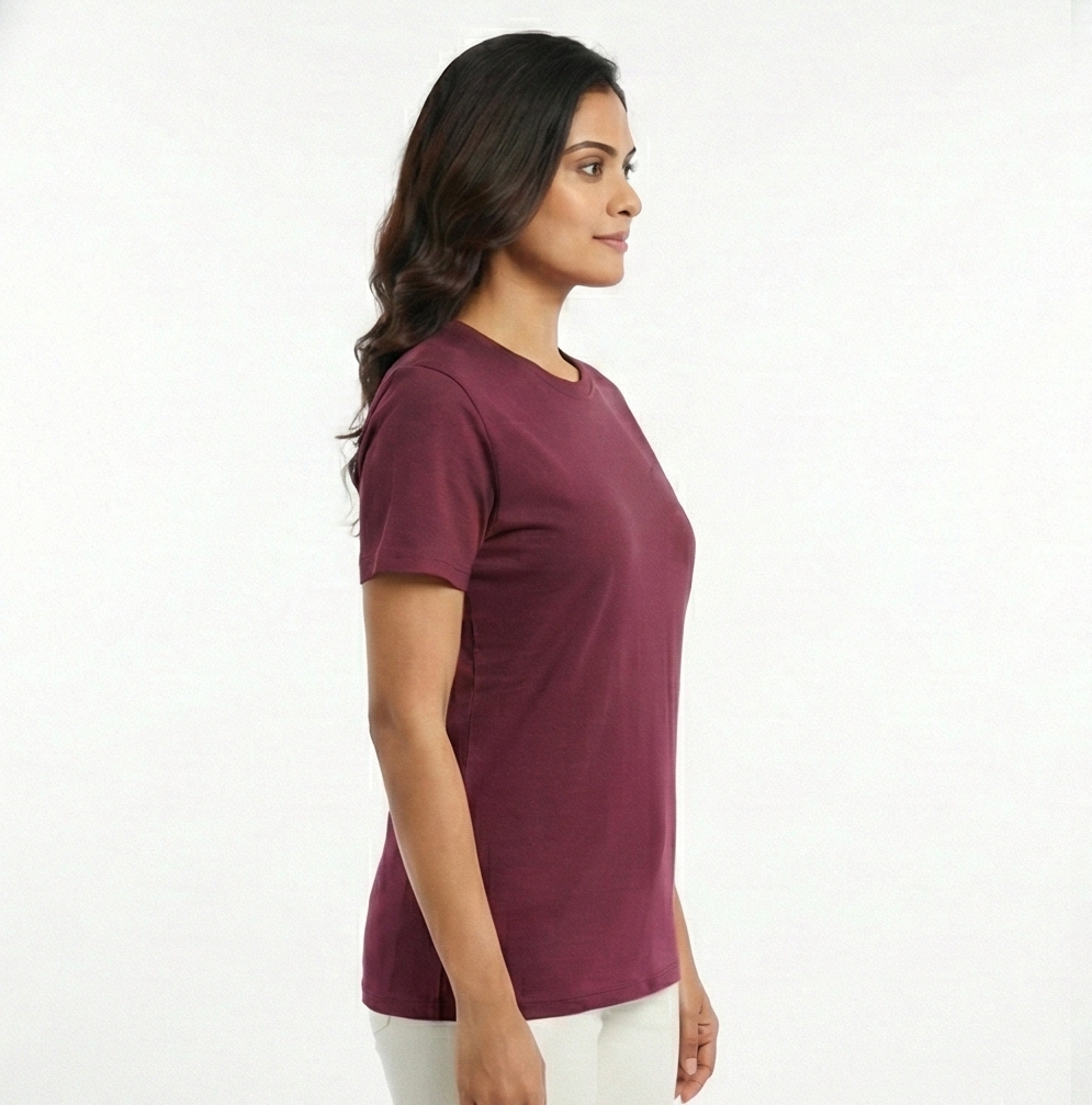 Woman wearing a maroon t-shirt and white pants on a white background