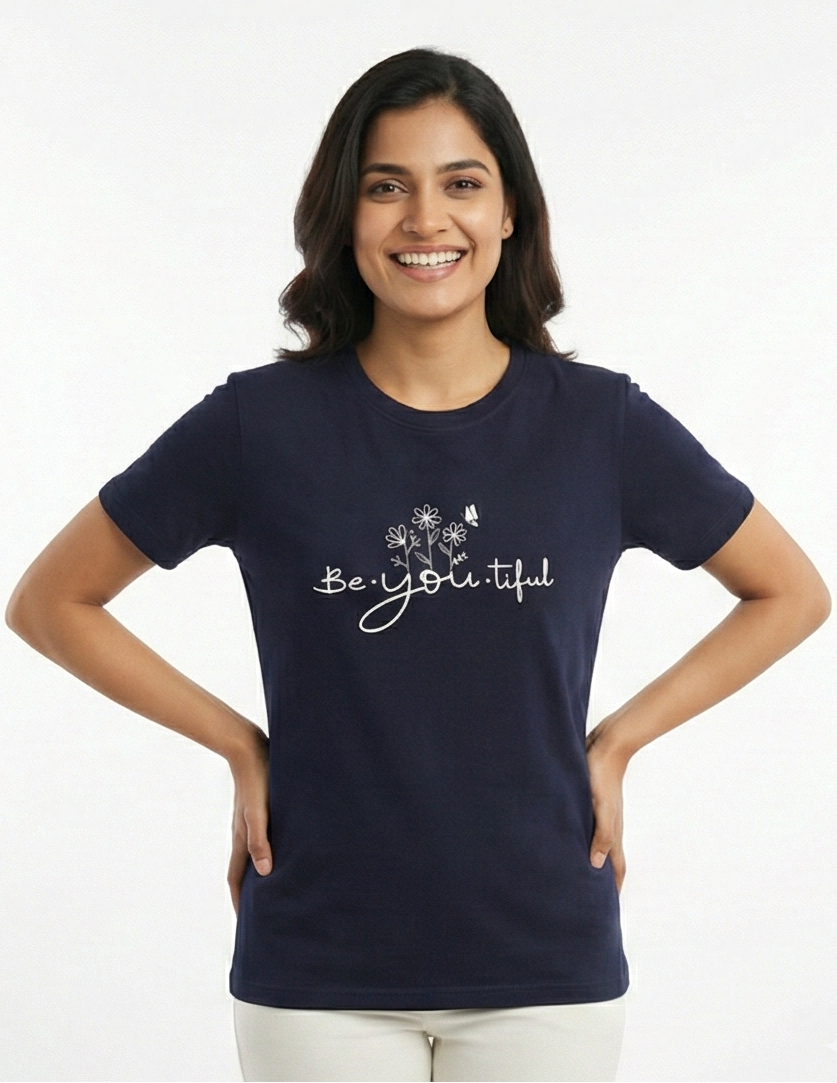 Woman wearing a navy blue t-shirt with 'Be Yoli-tiful' text on a white background
