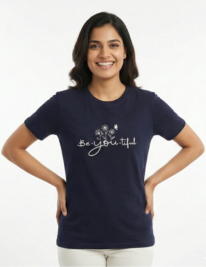 Woman wearing a navy blue t-shirt with 'Be Yoli-tiful' text on a white background