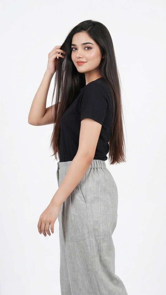 Woman wearing a black top and gray pants on a white background